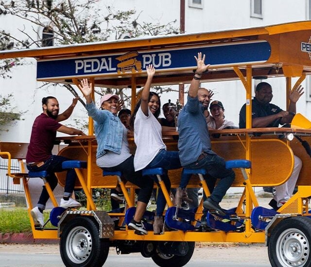 pedal pub tour guests waving from bike