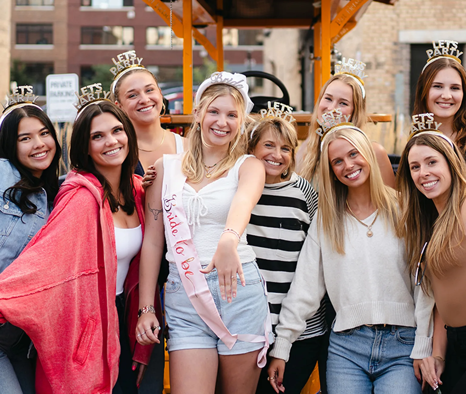 bachelorette party posing in front of Pedal Pub bike
