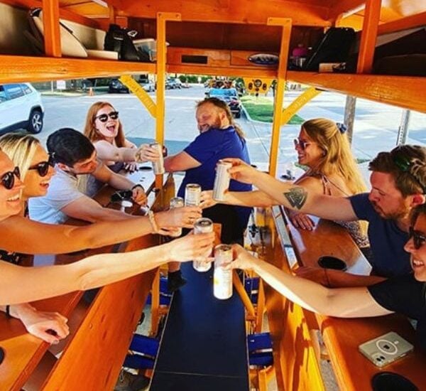 guests cheersing while on a pedal pub charlotte party bike