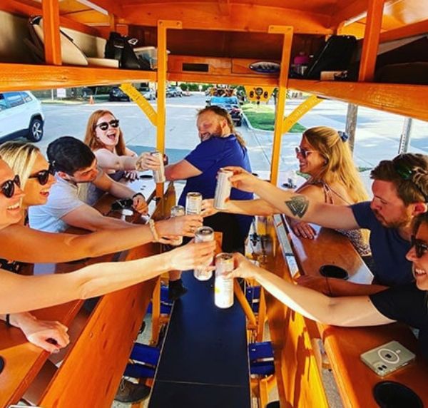 guests cheersing while on a pedal pub charlotte party bike