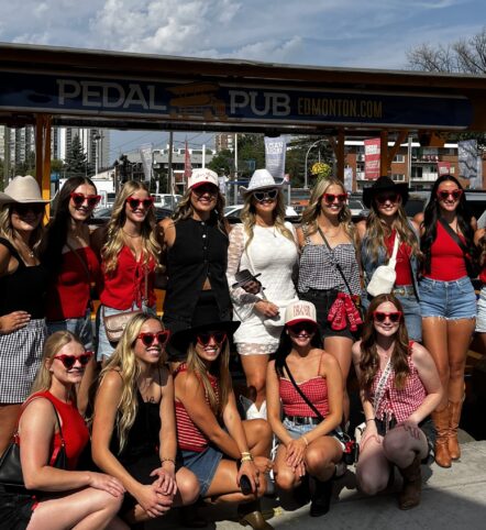 bachelorette party posing in front of party bike