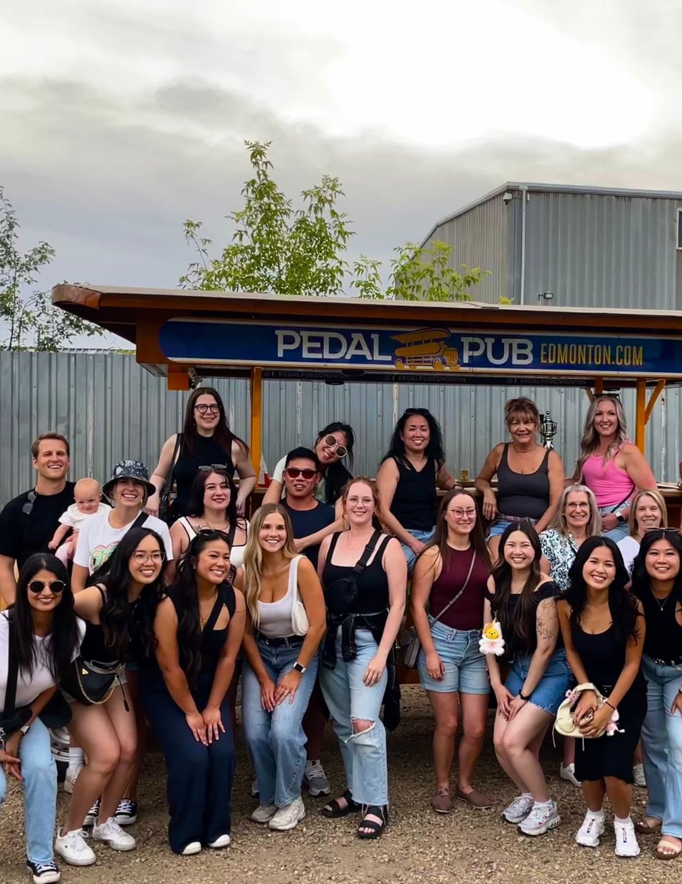 team posed in front of Pedal Pub party bike for team outing