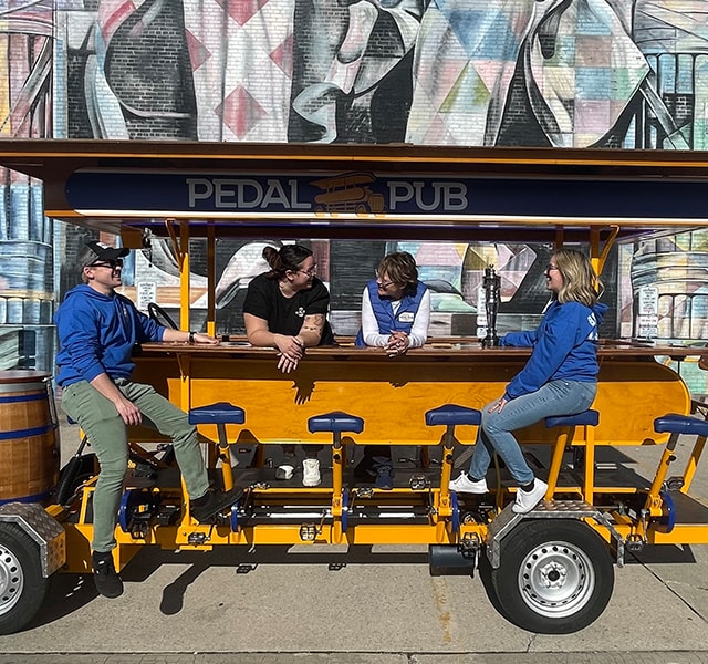 pedal pub driver and workers sitting on bike