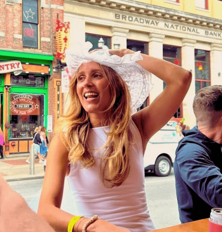 Woman in bachelorette party sitting in party bike dressed in white