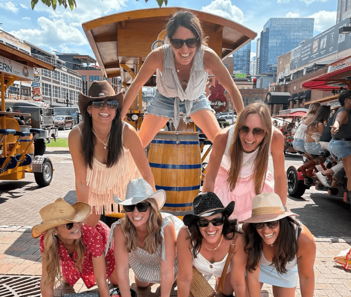 birthday party guests posing in a pyramid in front of party bike