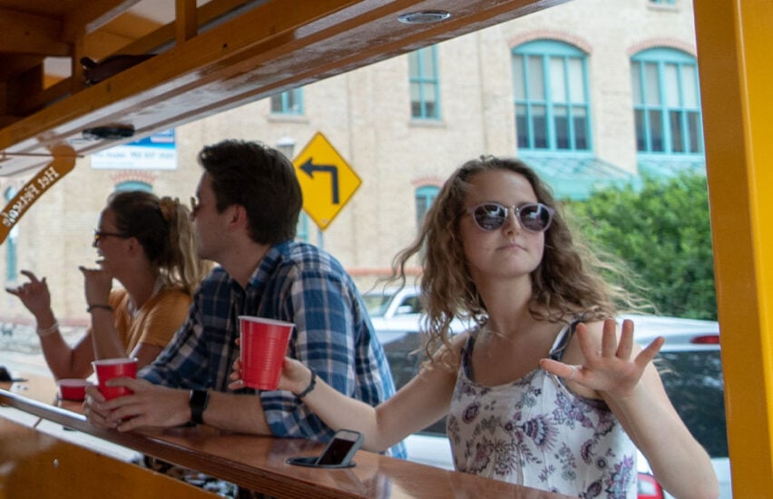 woman dancing to music on pedal pub