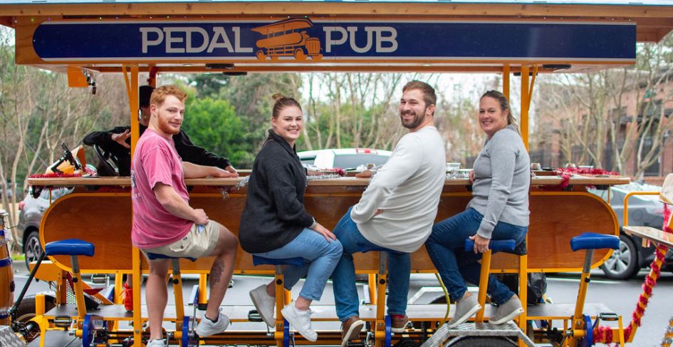 close-up of group of friends smiling on the pedal pub bike