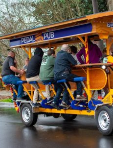 back view of people sitting on pedal pub bike
