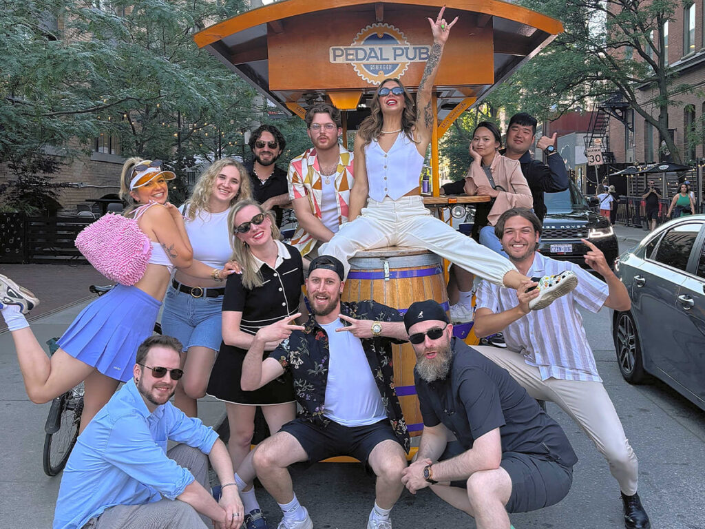 a birthday party doing fun poses around a party bike