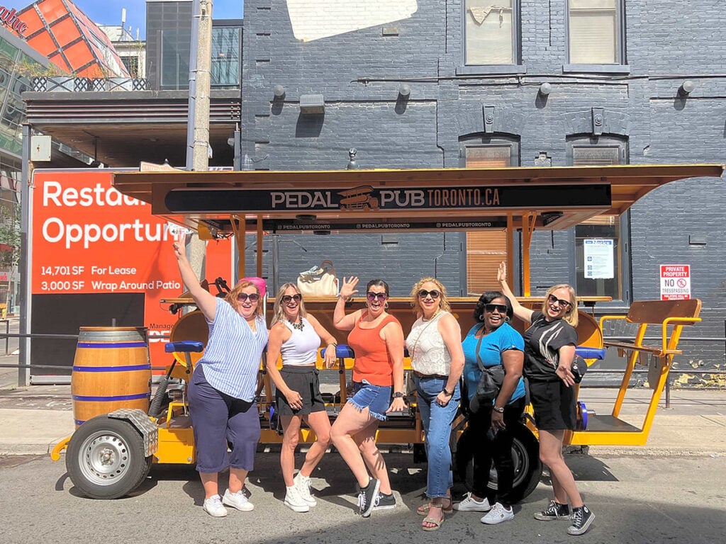 a group of women posing by a party bike
