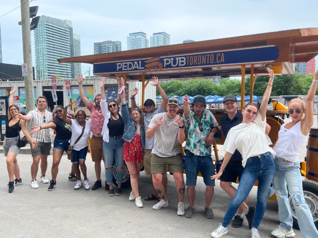 people posing in front of Pedal Pub bike