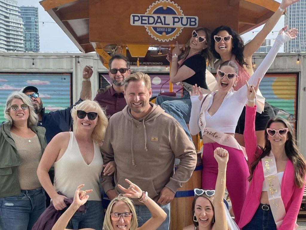 group of people standing around party bike