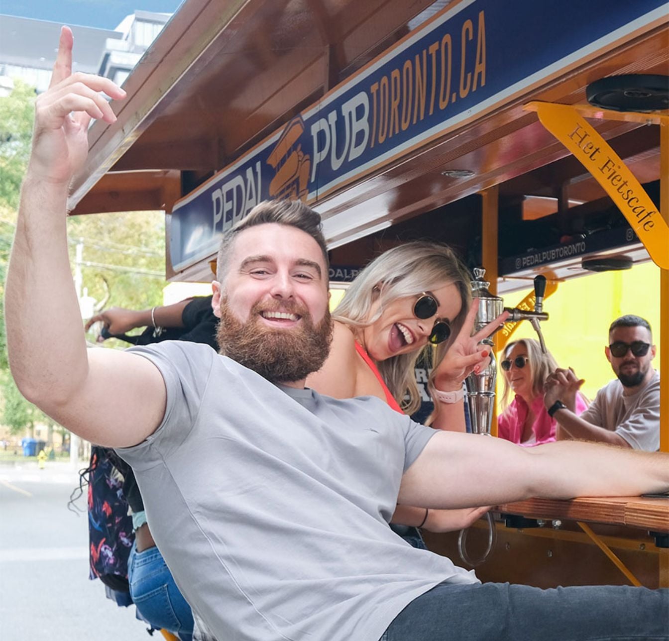 man and woman seated on party bike posing