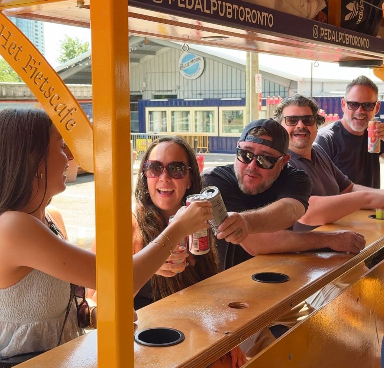 friends cheersing their drinks on a party bike