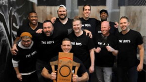 group of male friends holding axe throwing trophy