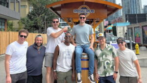 male friends posing in front of party bike
