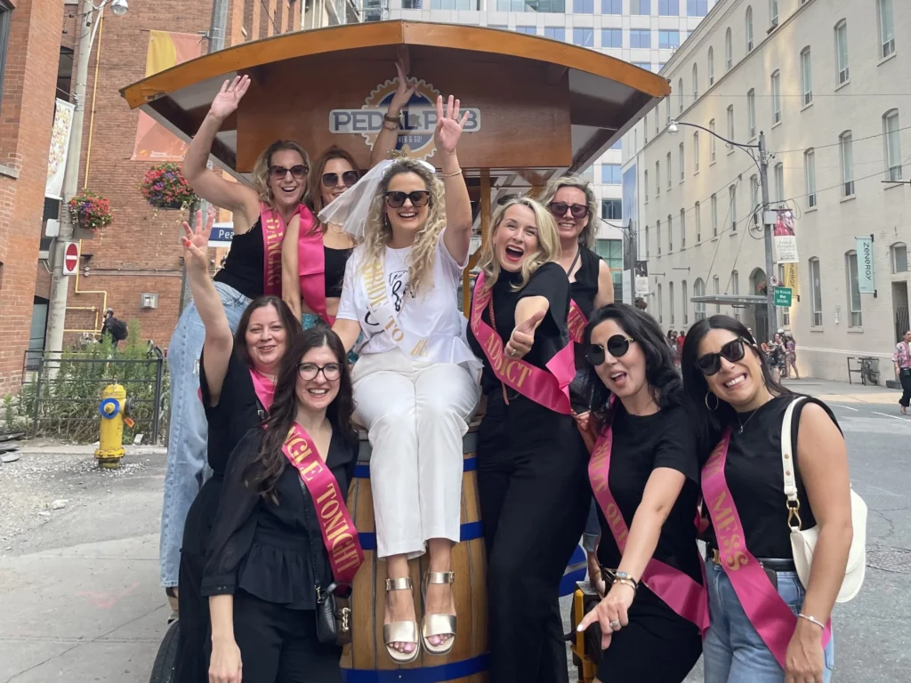 Bride in white with veil and friends celebrating on a Pedal Pub Toronto bachelorette party