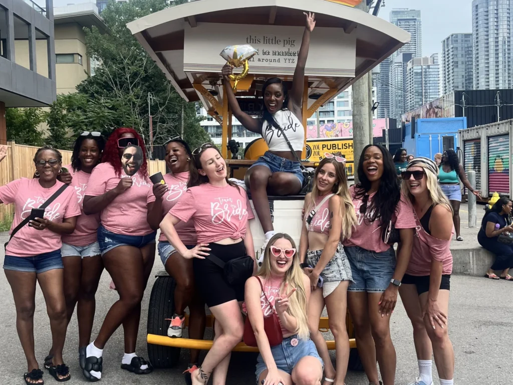 Bride with balloon and friends in matching Team Bride shirts on a Pedal Pub Toronto bachelorette tour