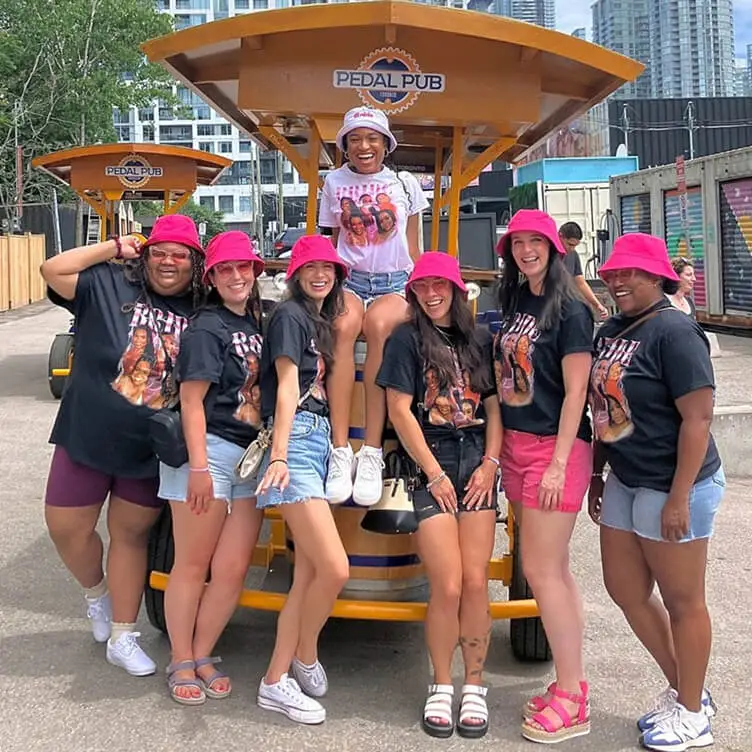 bride and bachelorette party standing around party bike