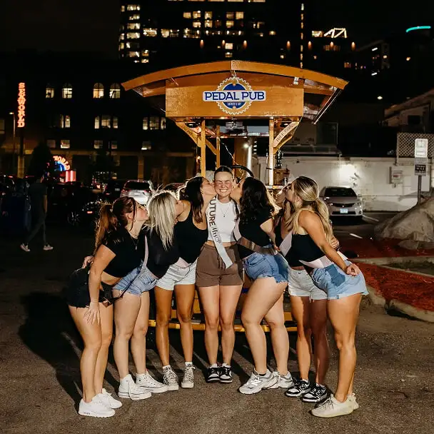 bridesmaids and bride posing on party bike