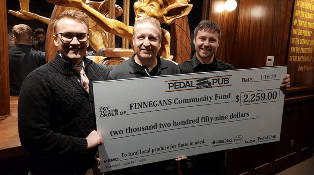 Pedal Pub team holding check with FINNEGANS staff