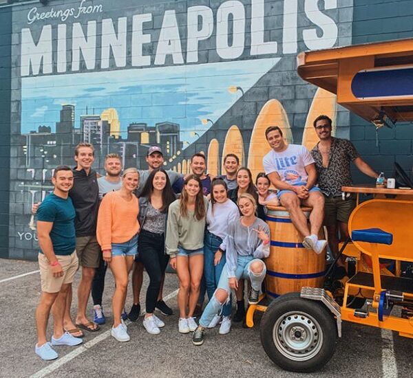 Pedal Pub riders in front of Minneapolis mural