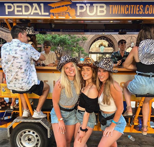 group of friends in front of Pedal Pub party bike