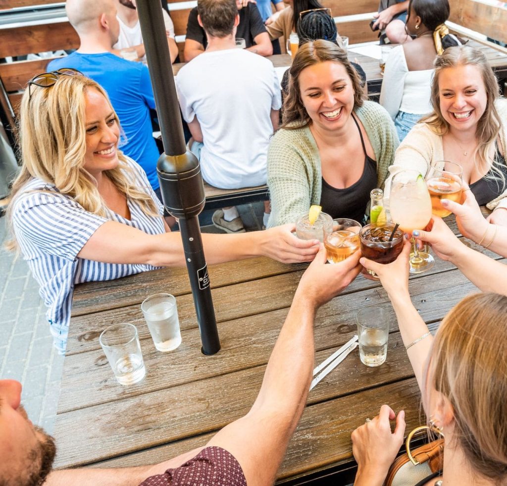woman cheersing drinks at Pedal Pub bar partner stop