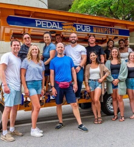 company posing in front of party bike in Winnipeg