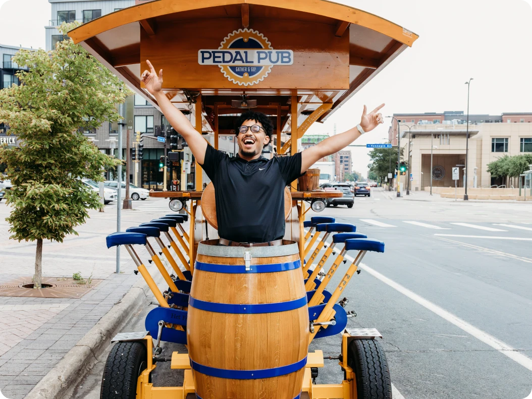 man jumping out of Pedal Pub beer bike barrel