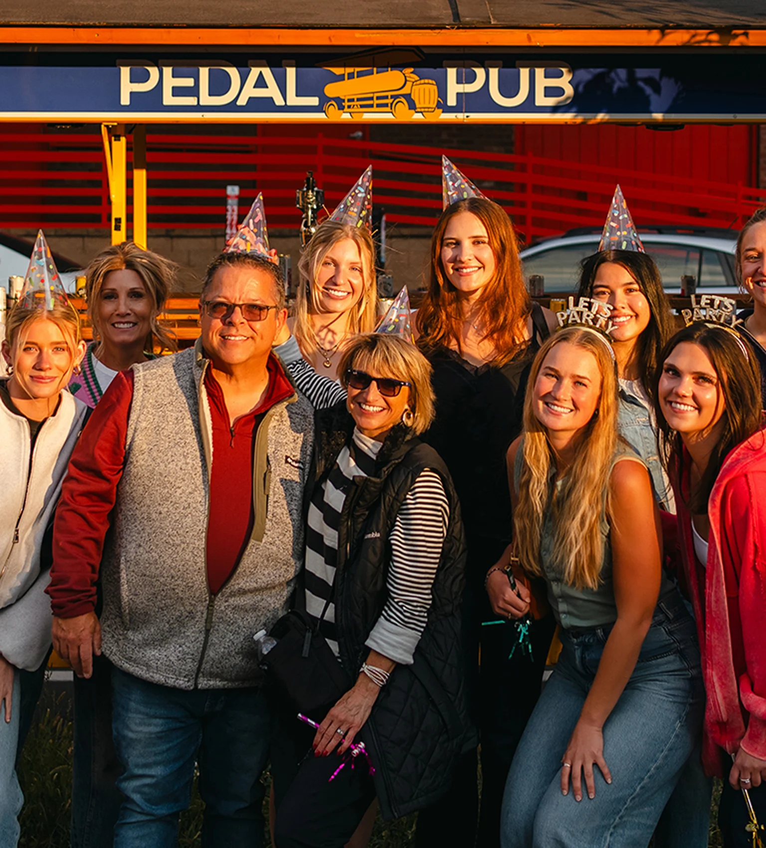 friends for birthday party in front of Pedal Pub bike with party hats