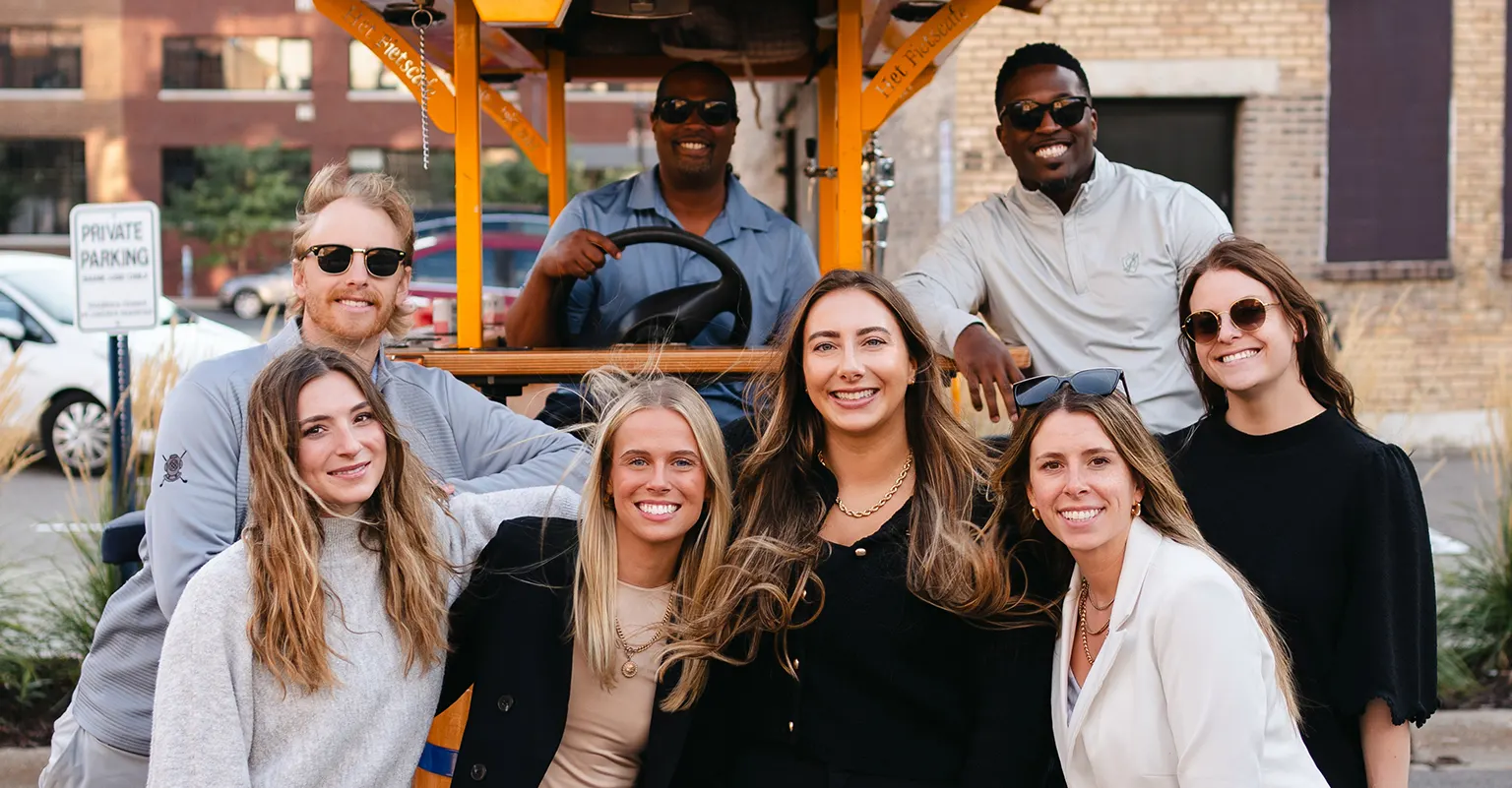 group posed in front of party bike